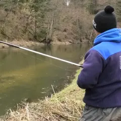 Wędkarz łowi na spławik w deszczu. Poznaj triki, jak łowić na spławik w deszczu i uniknąć przyklejania żyłki do wędki.