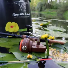 Delikatny spławik na karasia w płytkim stawie komercyjnym, obok wędki i przynęty.
