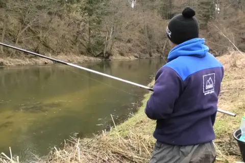 Wędkarz łowi na spławik w deszczu. Poznaj triki, jak łowić na spławik w deszczu i uniknąć przyklejania żyłki do wędki.