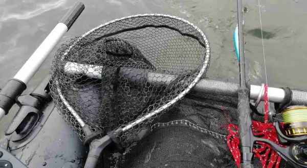 Łowienie na muchę z belly boat. Bezpieczne rzucanie sznurem z wody wymaga wprawy. Widoczny podbierak, wędka i kołowrotek.