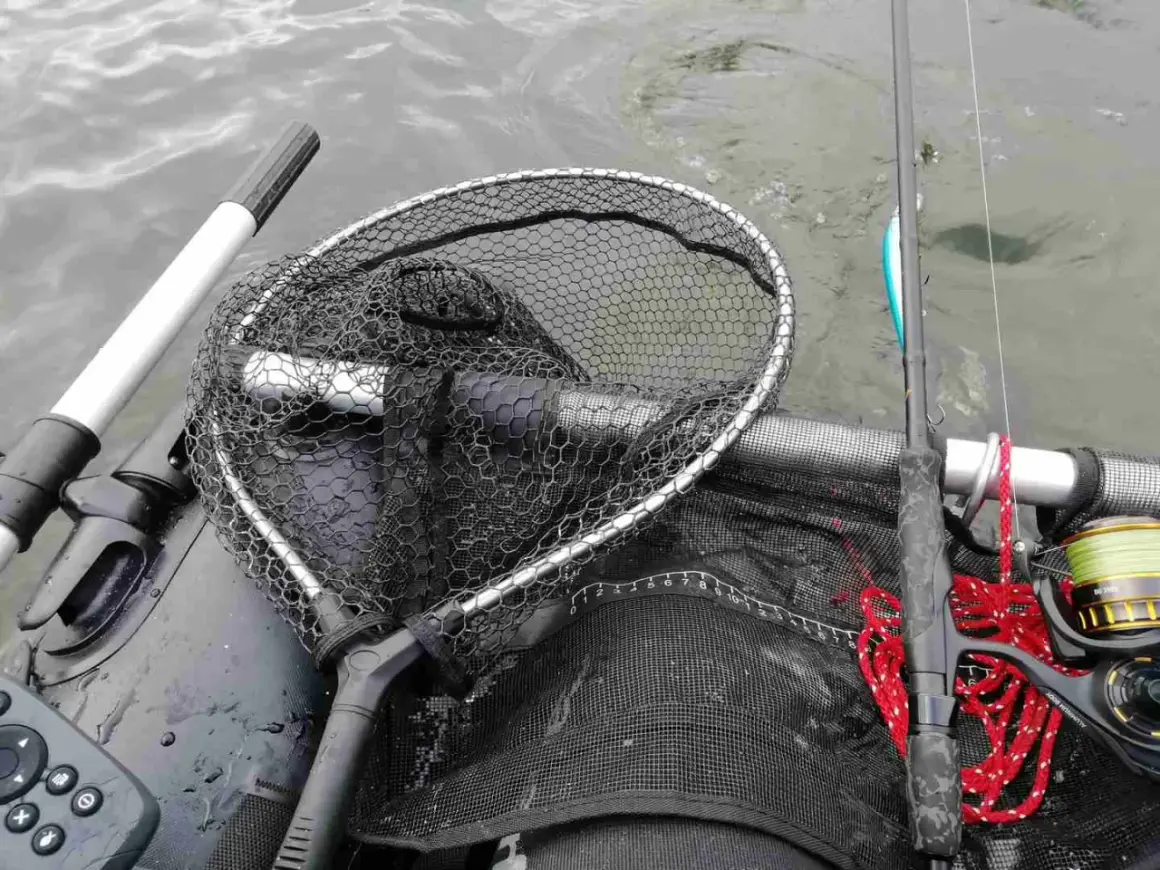 Łowienie na muchę z belly boat. Bezpieczne rzucanie sznurem z wody wymaga wprawy. Widoczny podbierak, wędka i kołowrotek.