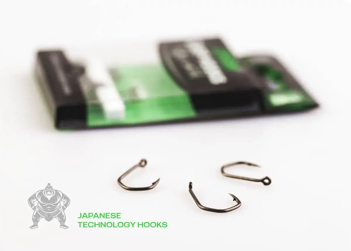 Czy haczyki karpiowe z teflonem faktycznie nie płoszą ostrożnych ryb? Trzy haczyki Japanese Technology Hooks leżą przed opakowaniem.