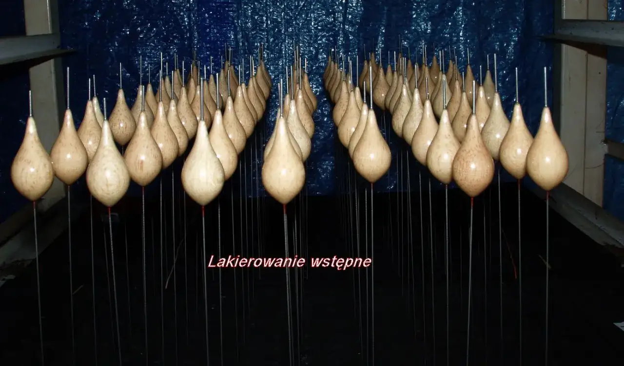 Lakierowanie starych spławików z balsy, by przywrócić im wyporność. Wiele drewnianych spławików w kształcie łzy wisi na cienkich drucikach.